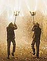 Two dancers of Ball de diables carrying fireworks.