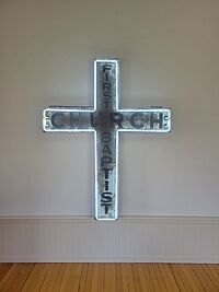 A white neon outlined cross with the word "Church" across the horizontal and "First Baptist" running down the vertical.