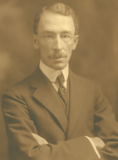 A sepia photo of a man in a suit with a tie.