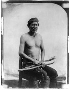 Manuelito, North American Indian, three-quarter length portrait, seated, facing front, holding bow and arrows LCCN89715882