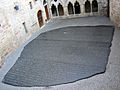 "Photo depicting a large copy of the Rosetta Stone filling an interior courtyard of a building in Figeac, France"