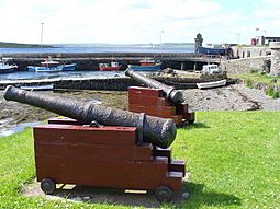 Cannon decorate the quayside of Balfour Harbour on Shapinsay, the round tower in the background is The Douche