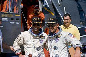 Astronauts Pete Conrad (right) and Richard Gordon pose in front of the recovery helicopter