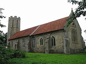 A stone church with a red tiled roof seen from the southeast with an octagonal west tower