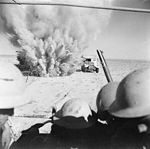 A mine explodes close to a British truck as it carries infantry through enemy minefields and wire to the new front lines