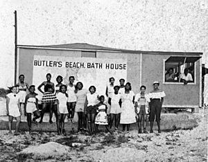 Beach-goers by the bath house at Butler Beach