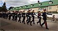 Soldiers marching down a street in black uniforms