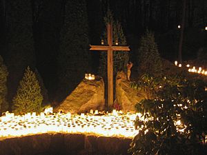 Hundreds of candles and a Christian Cross at a cemetery on Christmas eve