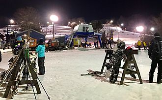 Mount Southington's Stardust, Avalanche and Thunderbolt ski lifts and trails lit at night.