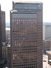 Aerial view of a 40-story skyscraper with a tan facade and dark windows; a major setback is visible near the building's roofline, at roughly the 35th floor