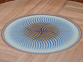 Circular design with orange centre surrounded by white and blue dots splaying out