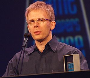 A man giving a speech after receiving an award for lifetime achievement at a game developers conference