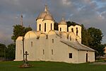 An old orthodox church with a white facade and metal-covered domes