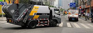 A residual waste truck and a household food waste truck on Zhonghua Road, Shanghai