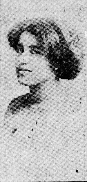Grainy, black and white head shot of a woman looking toward the camera and slightly smiling
