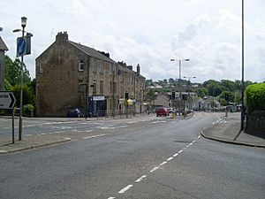Road junction with view towards three-storey sandstone buildings