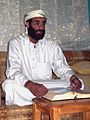 Anwar al-Awlaki sitting on couch, lightened