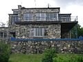 photograph of a stone-built house in 'International' style, with blue woodwork