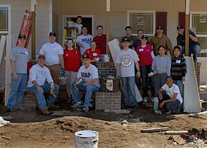 US Navy 080208-N-2564M-118 Sailors stationed aboard the amphibious assault ship USS Wasp (LHD 1) pose for a photograph at the Habitat for Humanity house they worked on as part of a community relations project