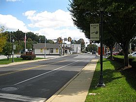 Jenkintown Road in Ardsley, looking southeast to the SEPTA crossing and two Edge Hill Road traffic signals. Several Battle of Edge Hill signs line the road.
