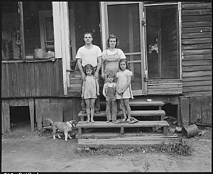Mr. and Mrs. James Wheeler and their three children. They have lived in the four room house, the porch of which they... - NARA - 541118