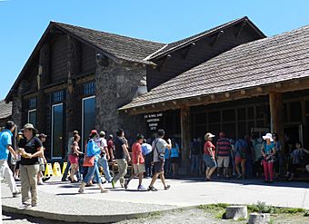 Old Faithful Lodge, visitor walking in front of building (9411306154).jpg