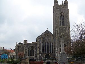 A flint church seen from the west, showing from the right, the tower and the west ends of the nave and the north aisle