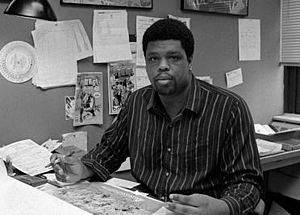 McDuffie seated at a drawing table