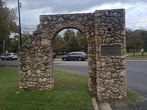 Photograph of a stone gateway bearing a bronze plaque reading "Pease Park"