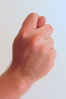 Gesture fist with thumb through fingers