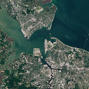 Satellite view of Hampton Roads with the Hampton Roads channel at center. (City urban centers visible, clockwise from top: Newport News, Hampton, Norfolk, Portsmouth)