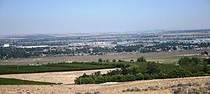 Finley shown with industrial complexes along Columbia River and orchards in the foreground