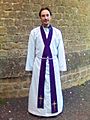 Anglican priest vested in an alb, cincture and purple stole