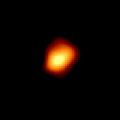 Grainy irregular shaped yellow spot with red rim on a black background