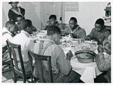 The Negro tenants and neighbors eating dinner after the whit... (3109741227)
