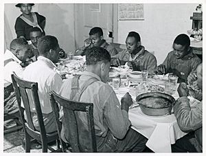 The Negro tenants and neighbors eating dinner after the whit... (3109741227)