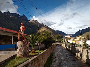 Calca Peru- canal through town and statue