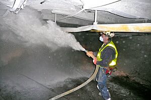 Coal miner spraying rock dust