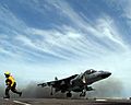 US Navy 050423-N-6214F-004 Aviation Boatswain's Mate 2nd Class Courtney F. Godfrey runs behind the foul line as a Marine Corps AV-8B Harrier II- performs a vertical takeoff