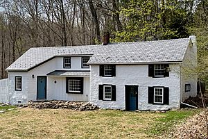 Stuccoed stone house with Colonial Revival embellishment