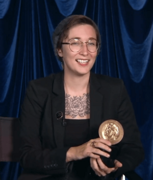 Terrace smiles, holding a gold Peabody Award trophy