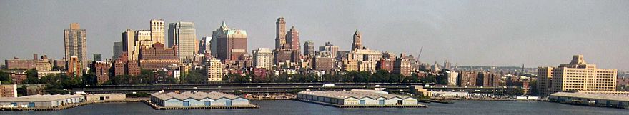 Downtown Brooklyn's skyline consisting of high-rise buildings, and docks in the foreground, viewed from across the East River from Lower Manhattan
