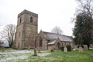 A stone church seen from the southwest, with a tower on the left, and a gabled south aisle and a porch on the right
