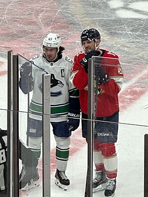 Sam Reinhart stands next to Quinn Hughes during a game against the Vancouver Canucks in November 2025