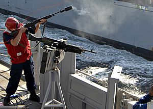 US Navy 090107-N-3392P-065 Gunner's Mate Seaman James Clarke fires a shot line to the Military Sealift Command dry cargo-ammunition ship USNS Lewis and Clark (T-AKE 1)