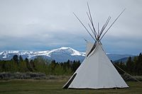 White teepee with mountains in background