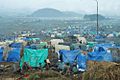 View of refugee camp on foggy day, showing tents of various colours and the refugees