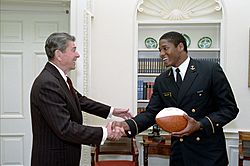 President Ronald Reagan during a photo opportunity with Napoleon McCallum Jr the star running back for the United States Naval Academy football team in the Oval Office
