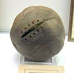 A worn, old brown football. One panel has space for stitches, but none are present.