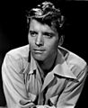 Black and white publicity photo of Burt Lancaster—a handsome white man with light eyes and wavy light-colored hair, oval face, wearing a light-colored shirt, around 34 years of age—in 1947.